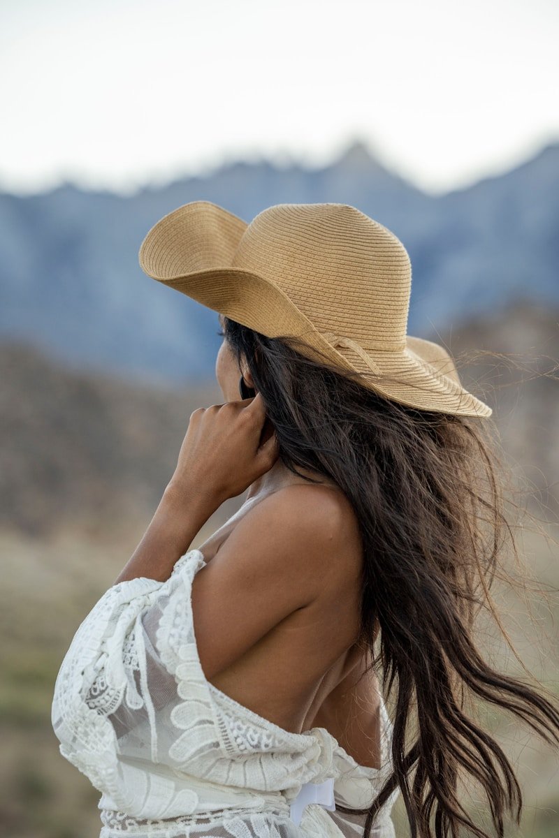a woman wearing a hat talking on a cell phone